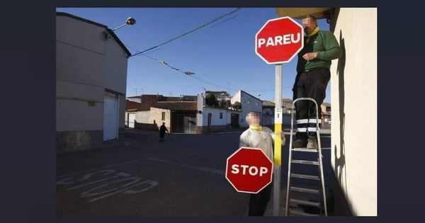 Foto: Empleados cambiando la señal de 'Stop' por la de 'Pareu'. (Policía)