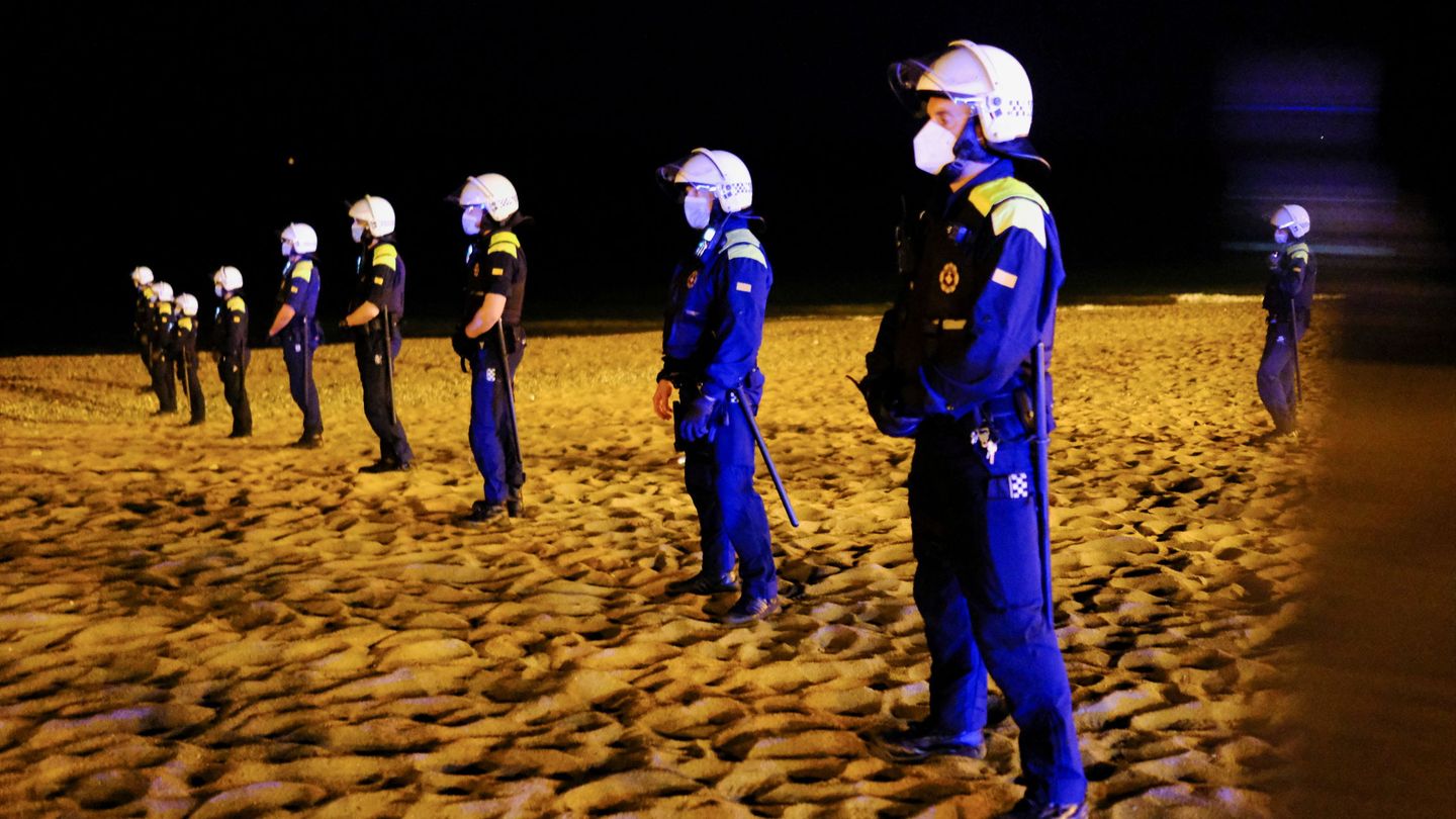 Policías controlan la playa de la Barceloneta durante la noche del pasado sábado tras el fin del estado de alarma. (Reuters)