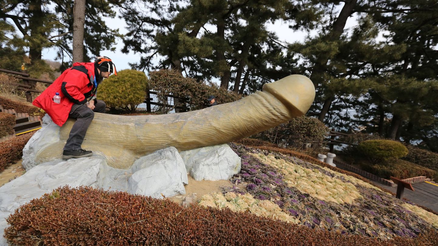 Un visitante se sienta sobre una escultura fálica en el parque Haesindang de la ciudad de Sinnam, Corea del Sur. (EFE/EPA/Tatyana Zenkovich)