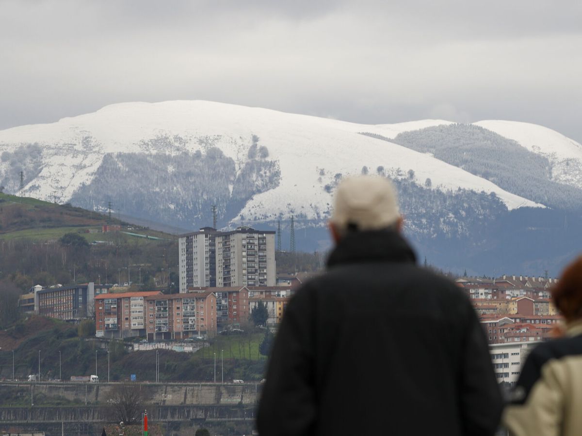 Foto: Dos personas abrigadas con el monte Ganekorgorta nevado. (EFE/Luis Tejido)