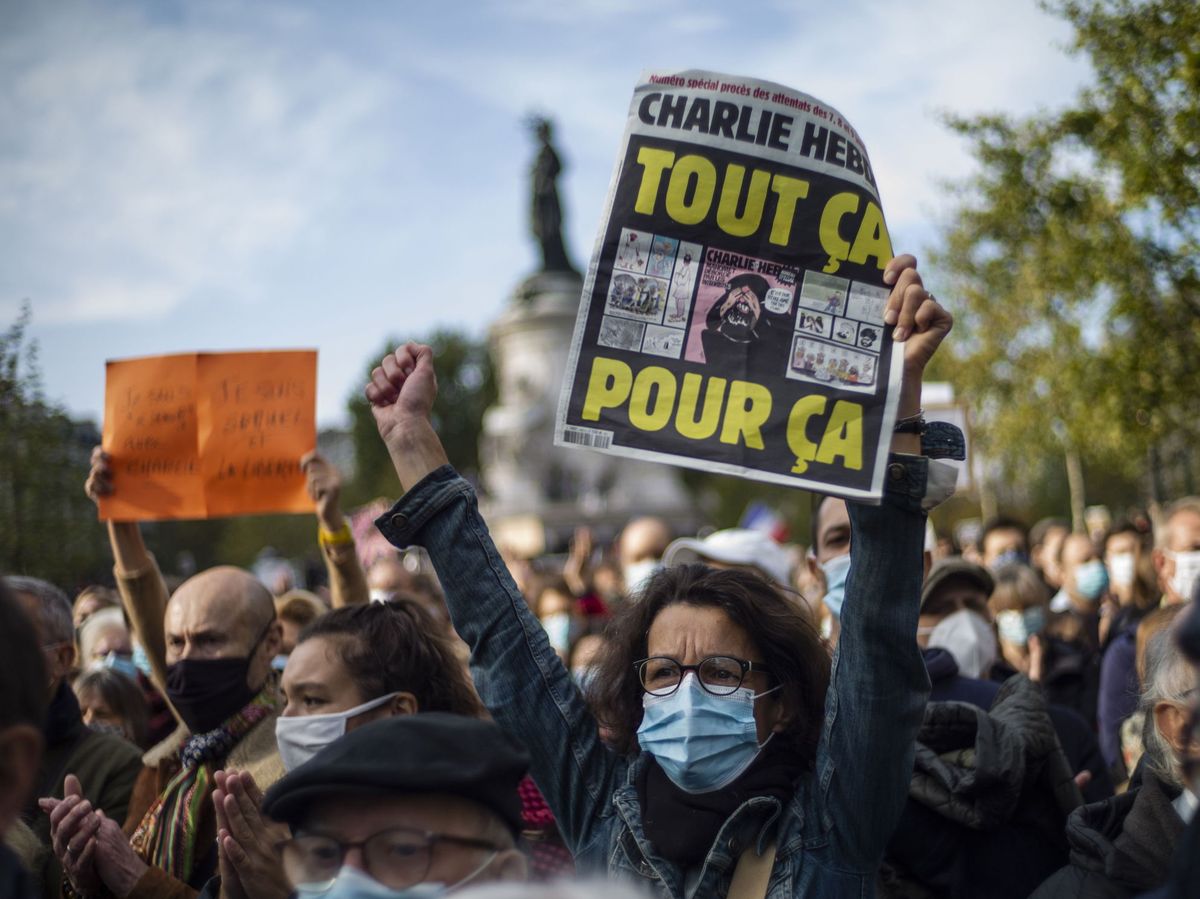 Foto: Una mujer sostiene la polémica portada del semanario satírico 'Charlie Hebdo' en una manifestación. (EFE) 