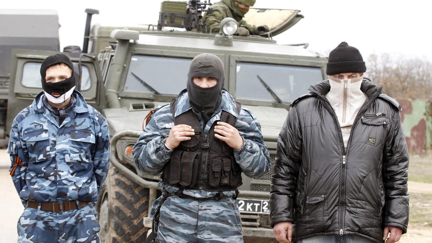 Milicianos prorrusoss y un vehículo del Ejército ruso en la base aérea de Belbek, Crimea (Reuters).