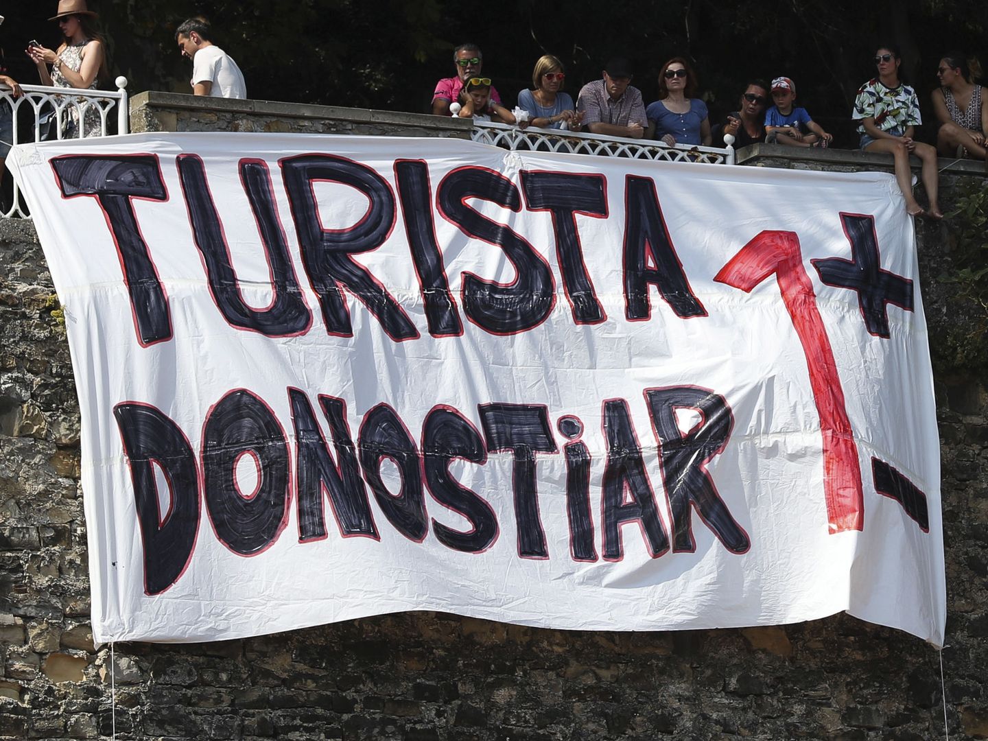 Un cartel en el que se lee 'Un turista más, un donostiarra menos' en la Semana Grande de San Sebastián.