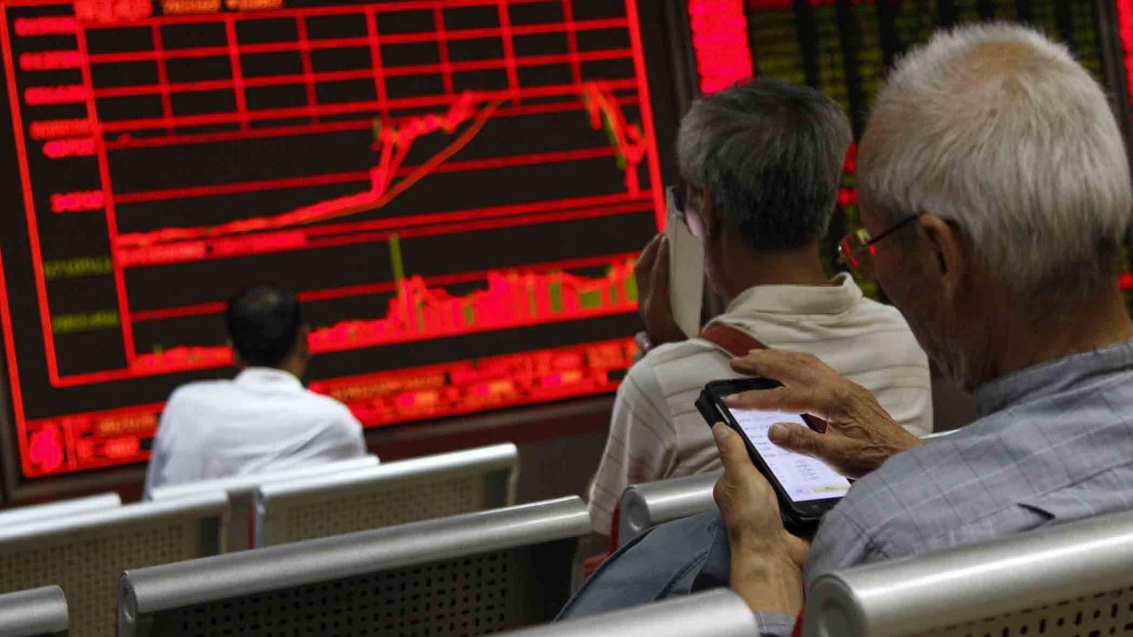 Foto: Un grupo de inversores mira una pantalla de cotizaciones en Pekín.