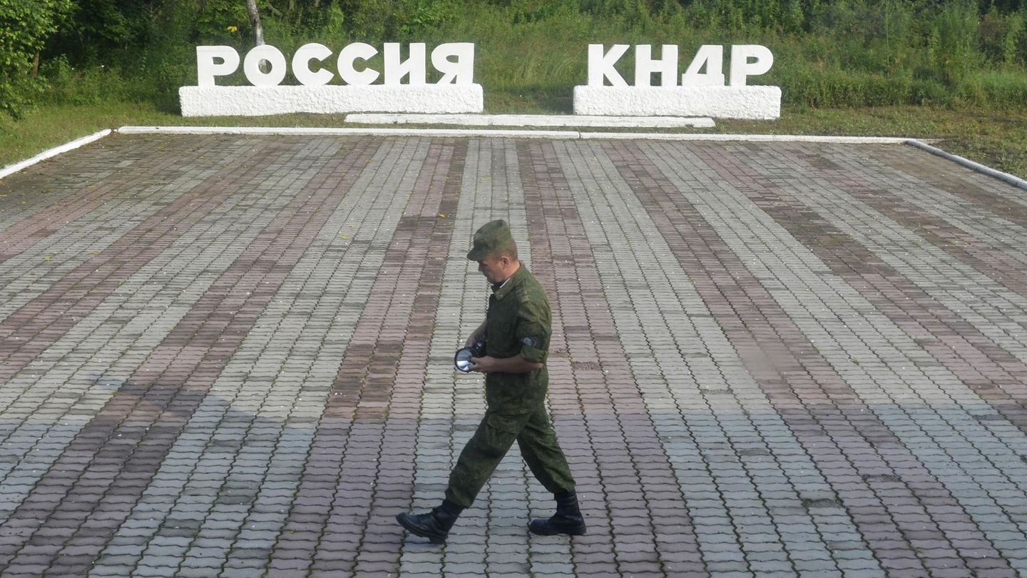 Un guardia pasa frente a dos carteles donde se lee 'Rusia' y 'RDPC', en el paso fronterizo de Tumangang entre Rusia y Corea del Norte. (Reuters)