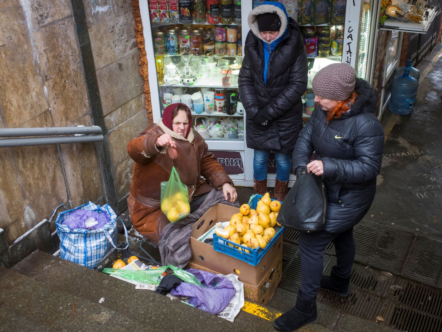 Una mujer vende peras a la entrada de un pasadizo en Kiev, el 15 de enero de 2019. (Reuters)