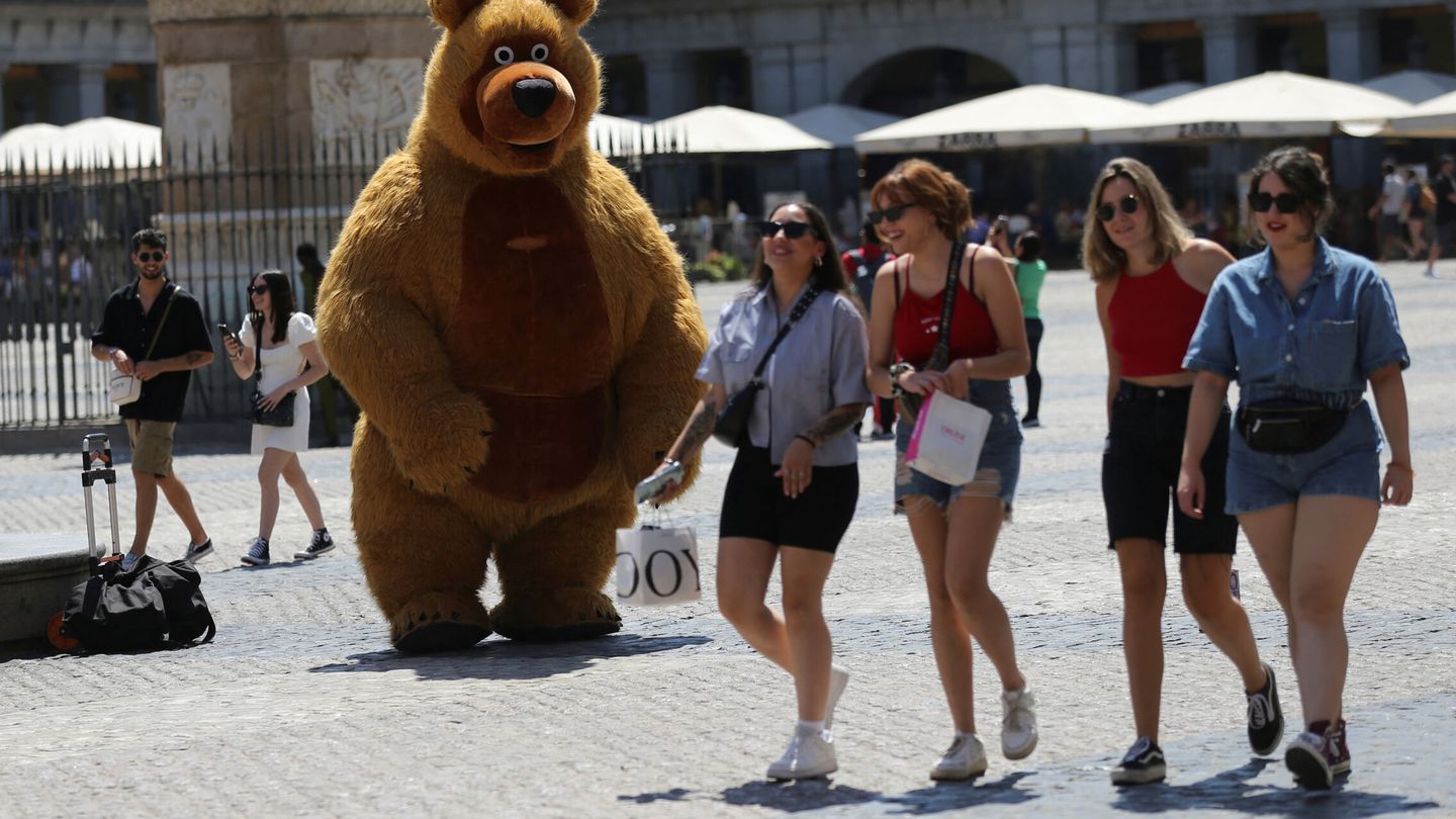 Una persona disfrazada de oso intenta conseguir alguna propina. (Reuters/I. Infantes)