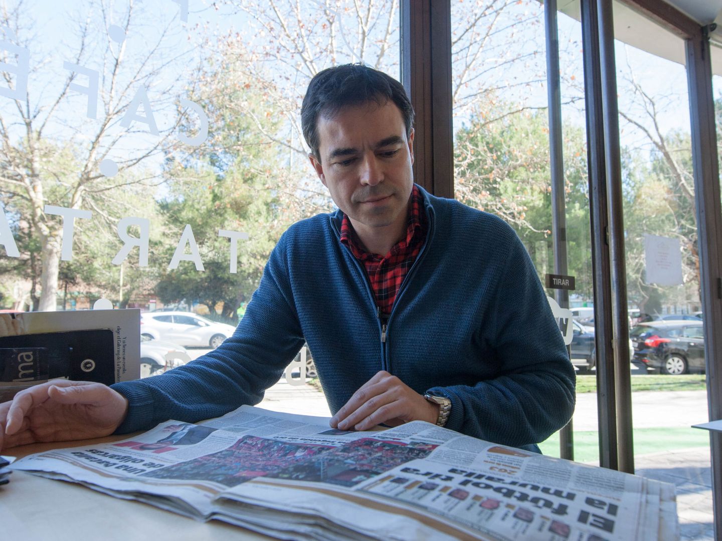 Andrés Herzog hojea un periódico en una cafetería. (David Brunat)
