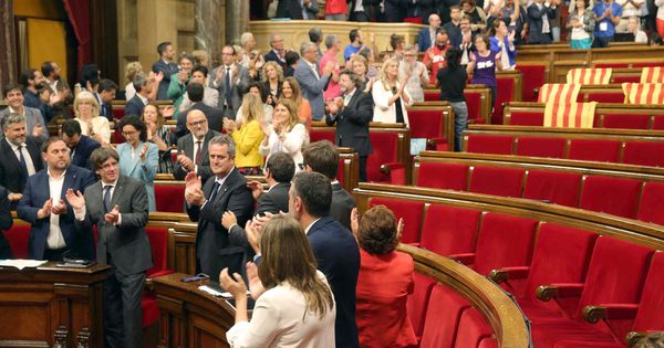 Foto: El presidente de la Generalitat, Carles Puigdemont (2i abajo), y su Gobierno celebran la aprobación de la ley del referéndum con los escaños vacíos de PSC, Ciudadanos y PPC. (EFE)