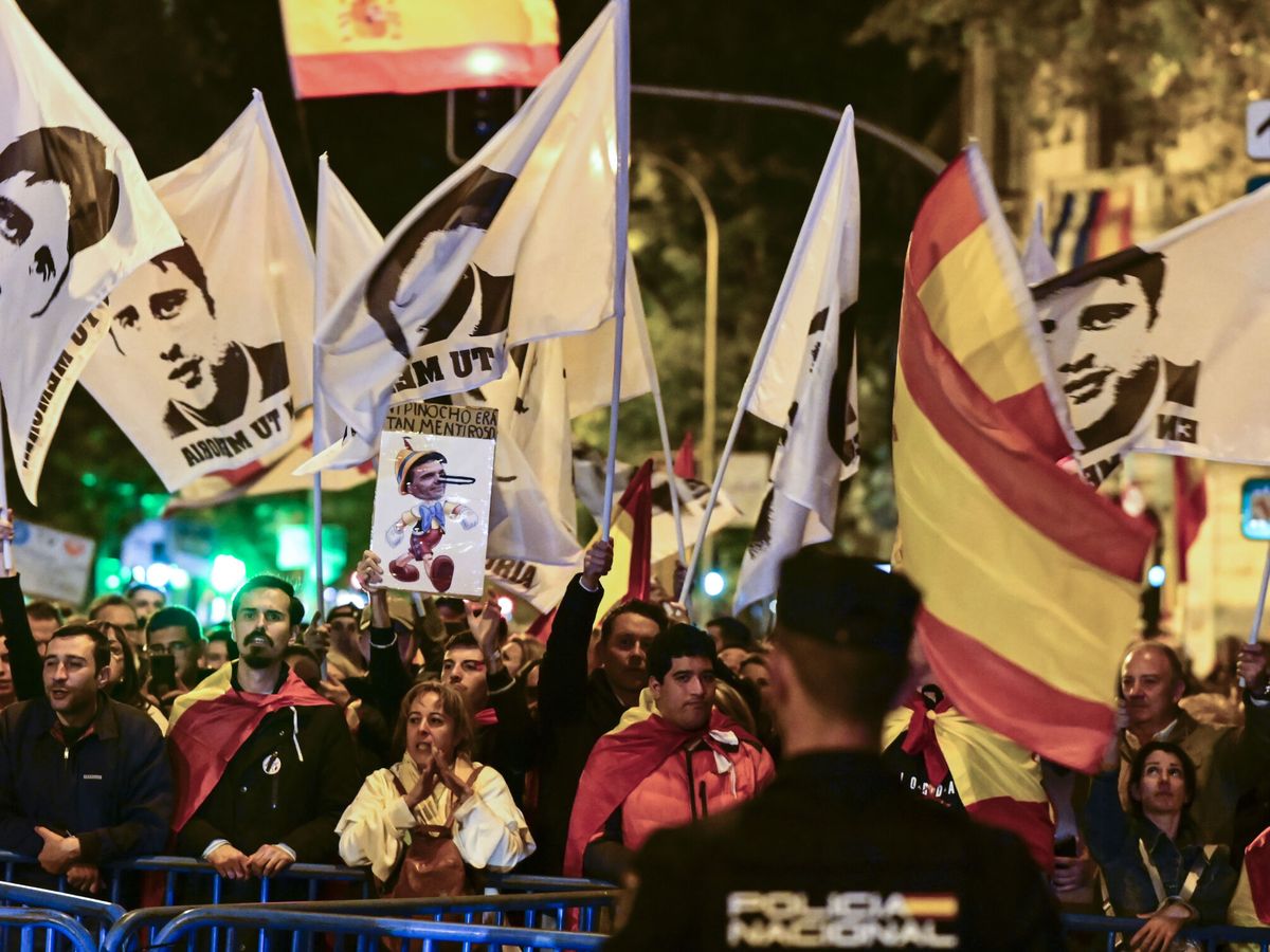 Foto: Unos jóvenes sostienen banderas de Miguel Ángel Blanco frente a la sede del PSOE en Ferraz. (EFE/Víctor Lerena)