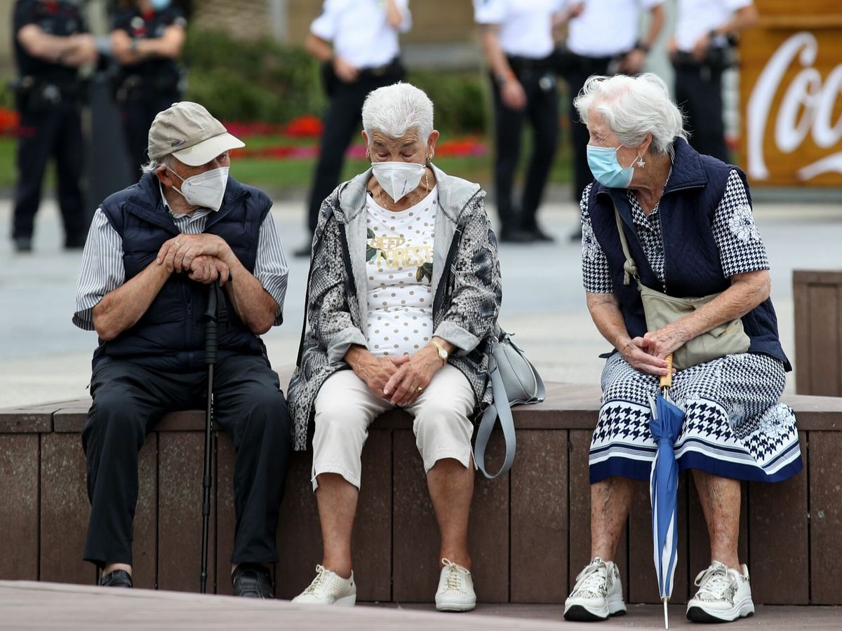 Foto: Unos ancianos conversan protegidos con mascarillas en San Sebastián. (EFE)