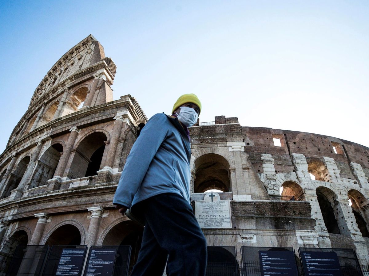 Foto: Un turista pasea junto al Coliseo de Roma con una mascarilla. (EFE)