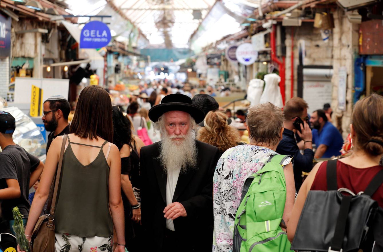 Un judío ultraortodoxo camina entre israelíes laicos por un mercado de Jerusalén. (Reuters) 