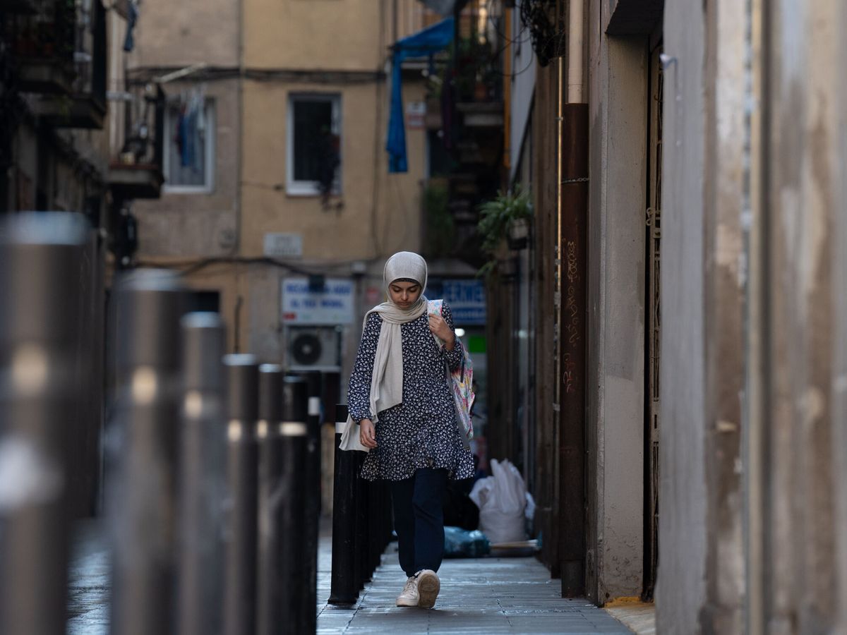 Foto: Una migrante pasea por una calle en Barcelona. (EP/David Zorrakino)