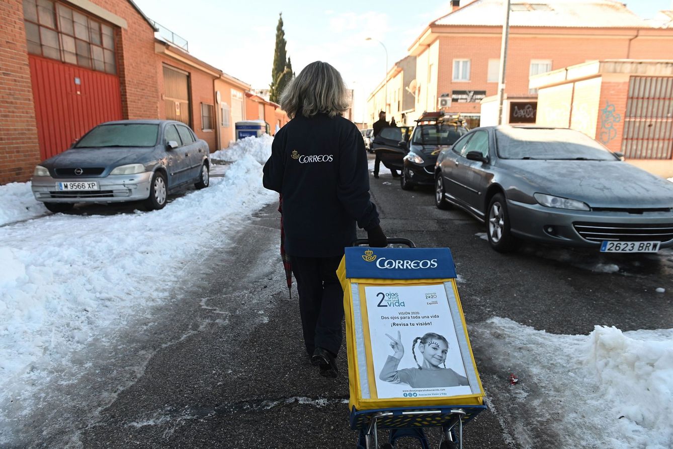 Una trabajadora de Correos reparte cartas en una calle cubierta de hielo. (EFE)