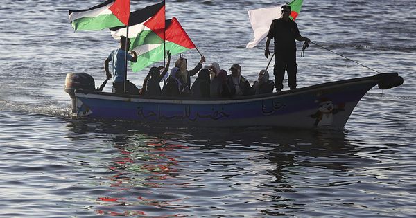 Foto: Varias mujeres palestinas ondean su bandera nacional en solidaridad con la coalición Flotilla de la Libertad cerca del puerto de Gaza, en octubre de 2016. (EFE)