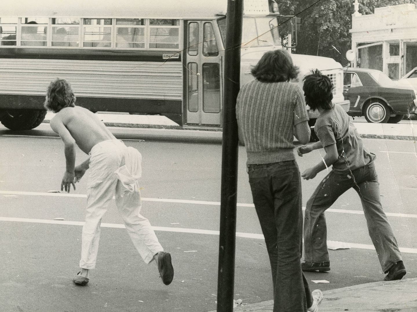 Un grupo de jóvenes lanza objetos contra un autobús en el primer día de colegio sin segregación racial en la educación pública de Boston, el 12 de septiembre de 1974. (Getty)