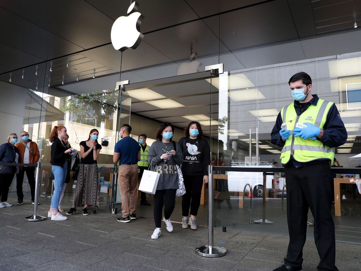 Foto: Clientes australianos esperan para someterse a un control de temperatura en una tienda de Apple. (EFE)