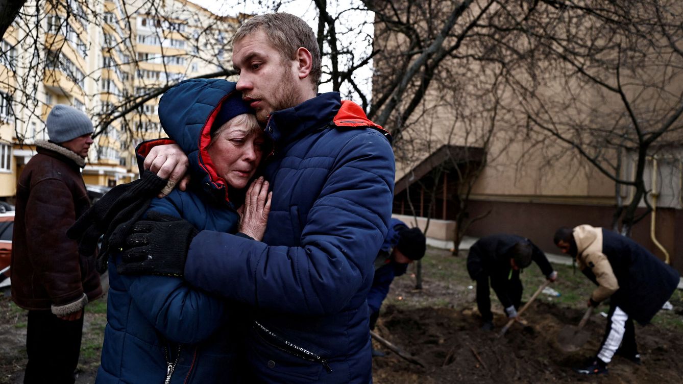 Foto: Dos ucranianos se abrazan tras la masacre de Bucha. (Reuters/Zohra Bensemra)