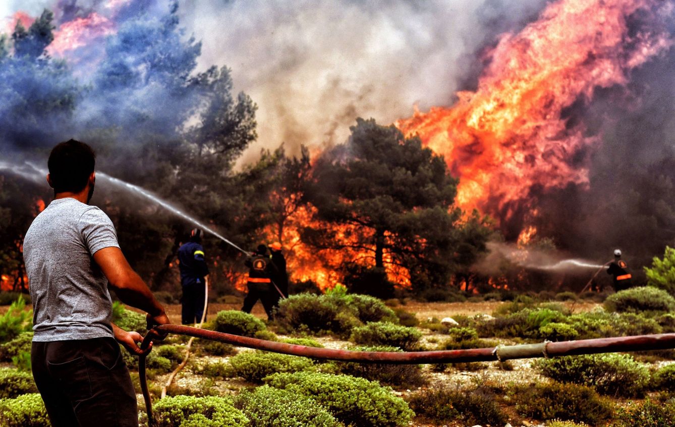 Bomberos y voluntarios luchan contra un incendio al sur de Grecia en 2018. (EFE/Vassilis Psomas)