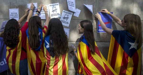 Foto:  Menores de edad con esteladas cuelgan carteles a favor de votar en el referéndum del 1 de octubre. (EFE)