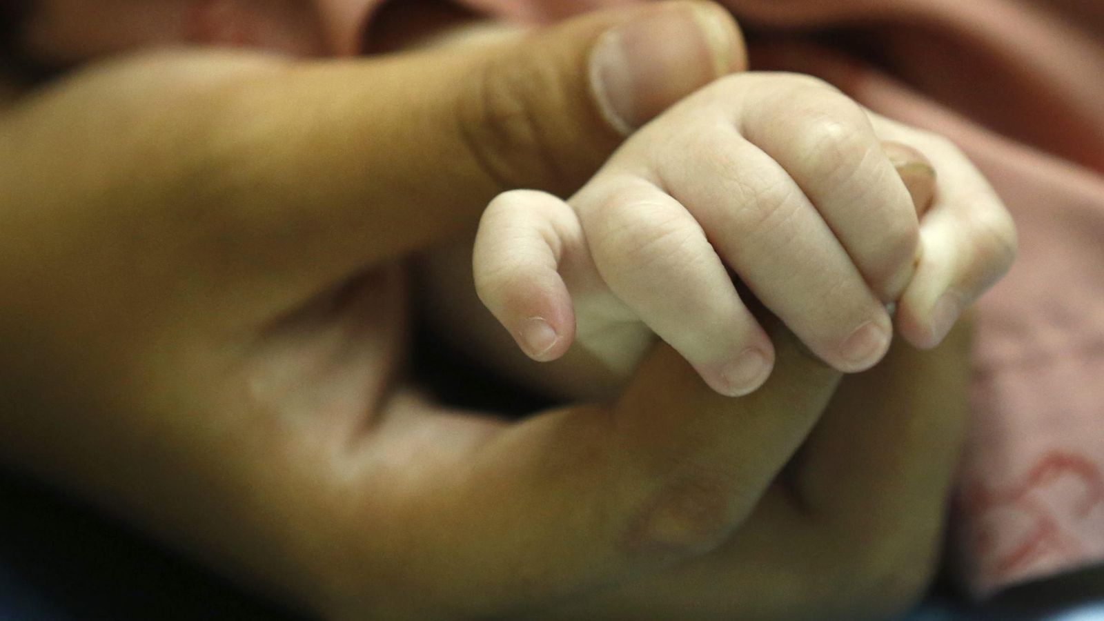 Foto: Un padre sostiene la mano de su bebé. (EFE)