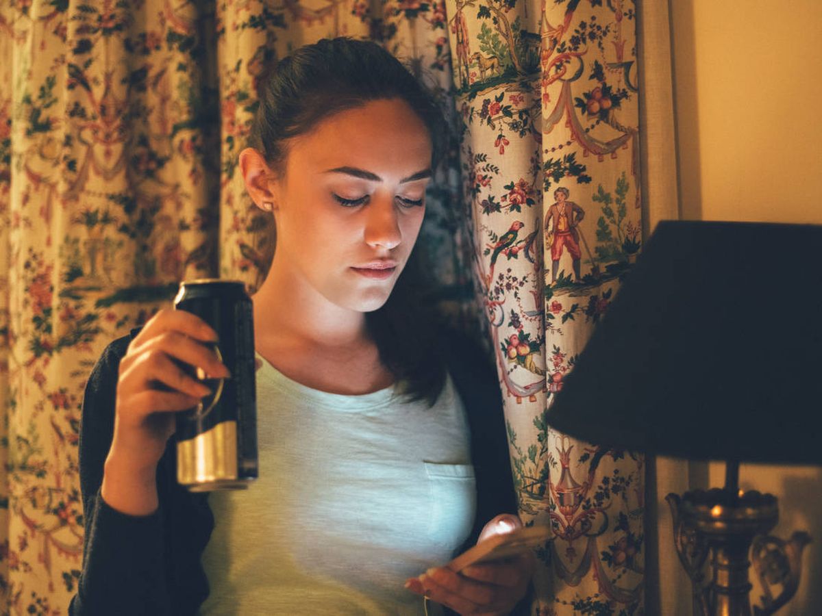 Foto: Chica en su habitación con el móvil. (iStock)