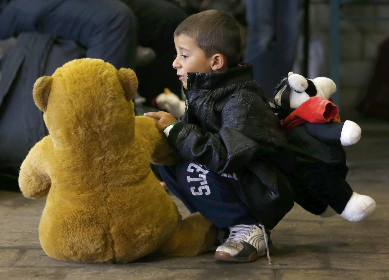 Un niño juega con un oso de peluche que le acaban de regalar los voluntarios en Viena (Reuters).