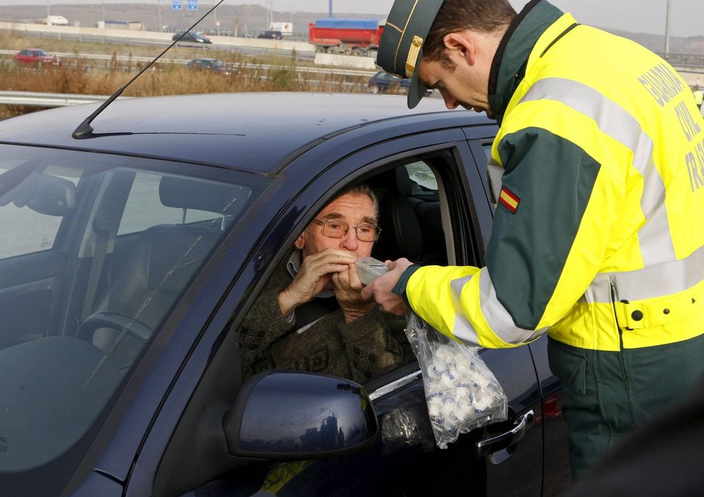 Foto: Un conductor realiza una prueba de alcoholemia a instancias de un guardia civil de tráfico en un control (Efe).