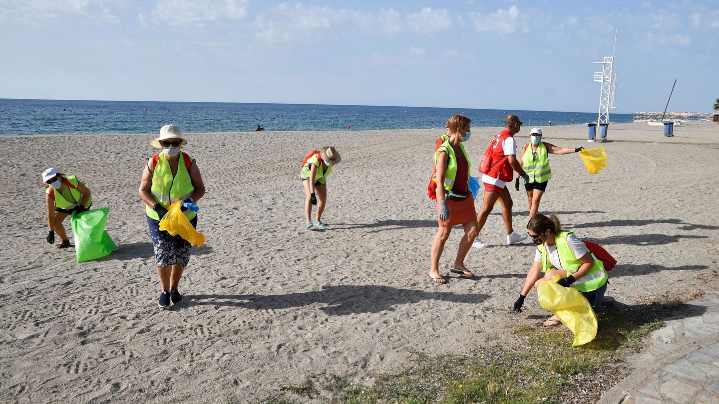Voluntarios recogiendo basuraleza de una playa (EFE Carlos Barba)