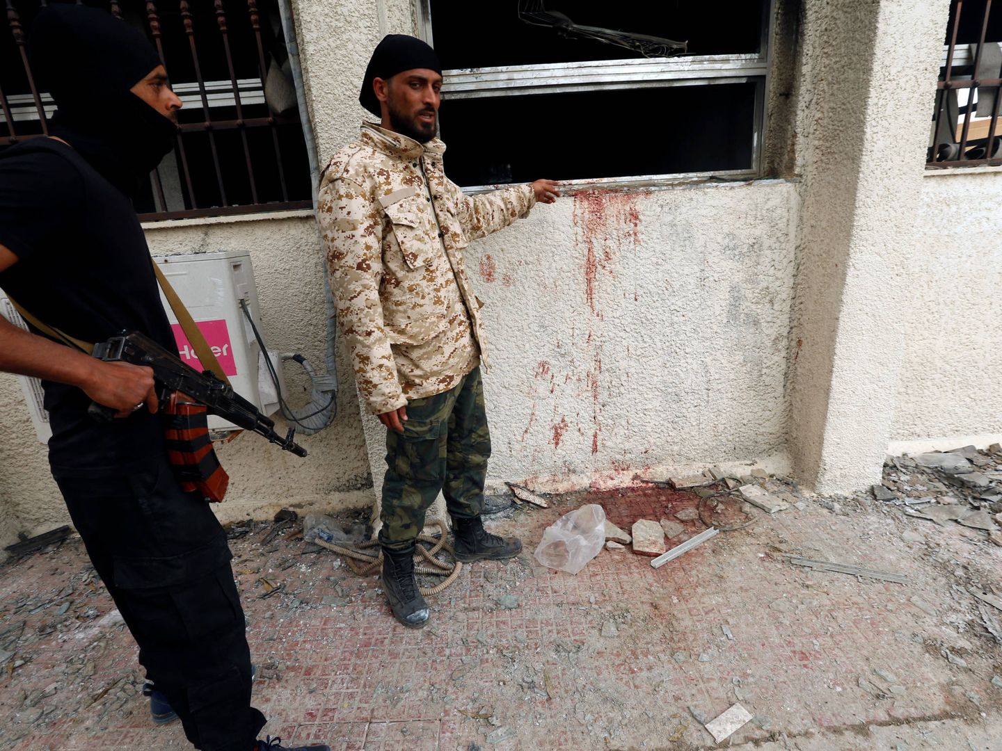 Personal de seguridad examina el lugar de un ataque suicida contra la comisión electoral en Trípoli, el 2 de mayo de 2018. (Reuters)