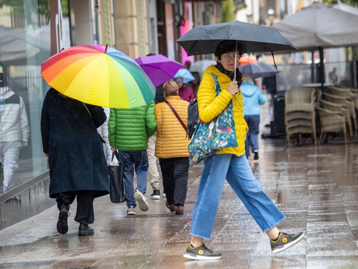 Foto: Un grupo de personas paseando con paraguas. (EFE/Raquel Manzanares)