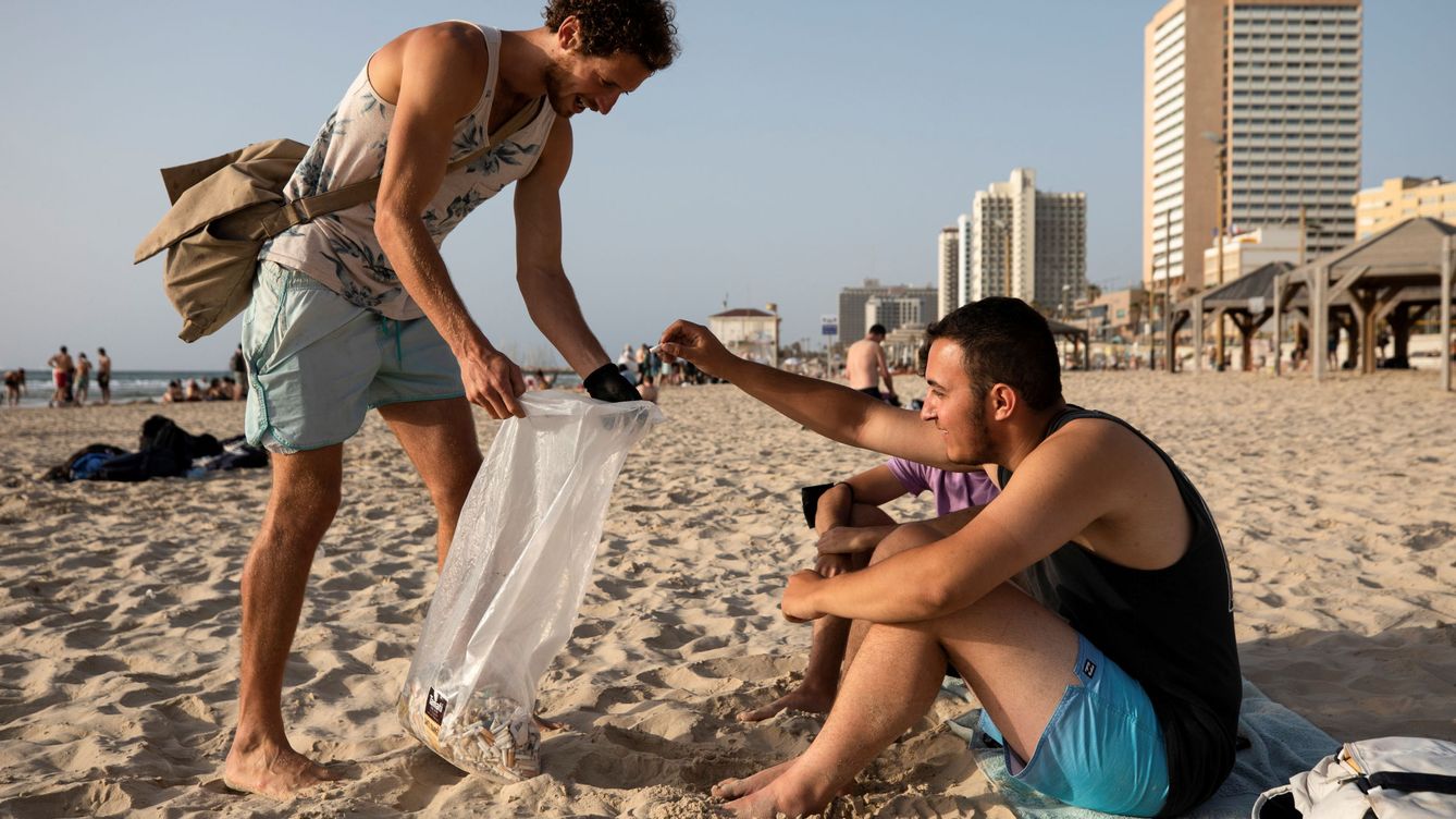 Foto: Un ciudadano recogiendo colillas en la playa. (Reuters/Amir Cohen)