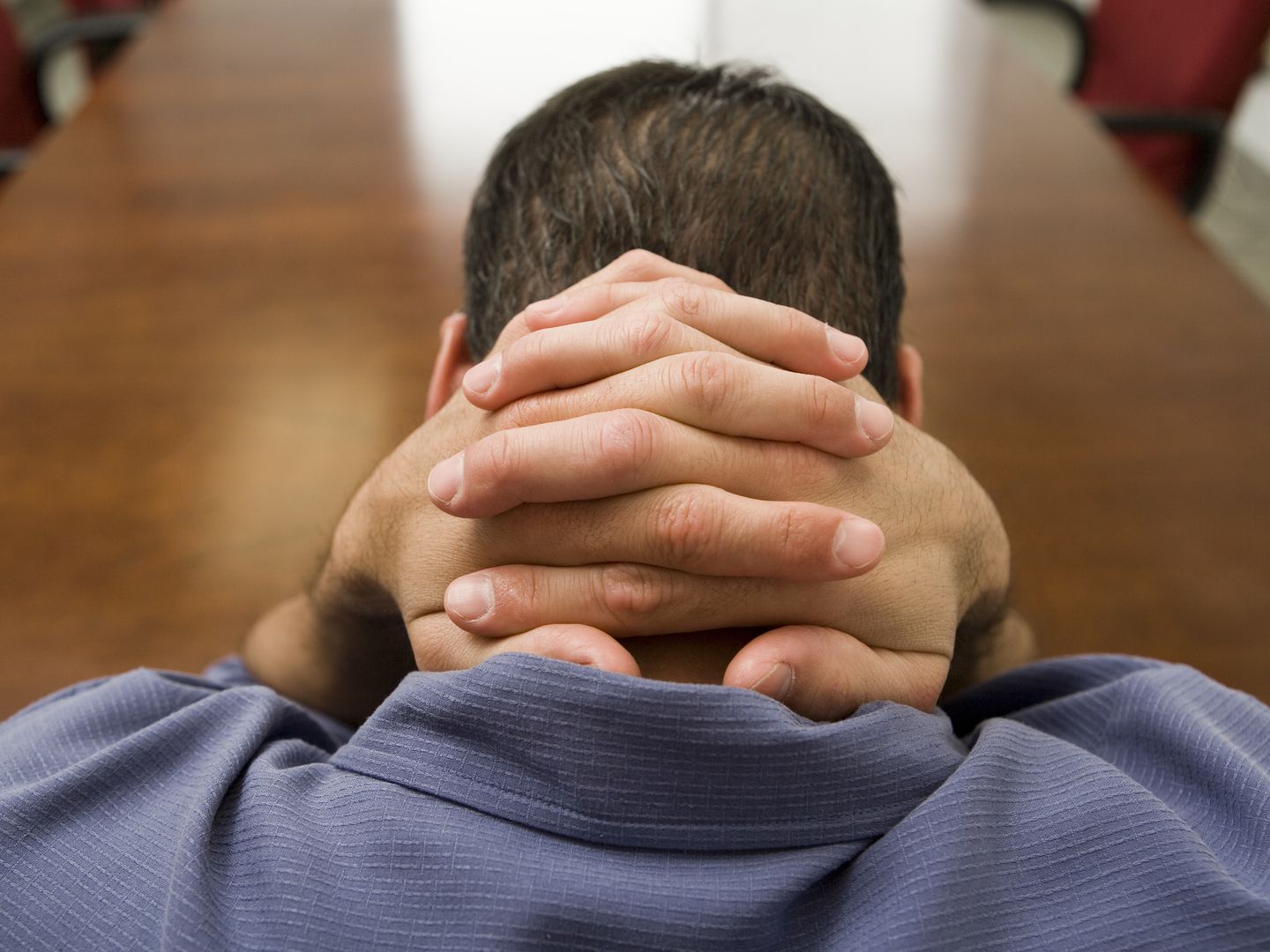 Stressed man with hands behind his head --- Image by © Bill Varie/Somos Images/Corbis