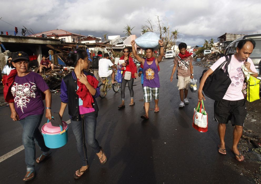 Foto: Un hombre carga con un saco de arroz por una carretera de Tacloban (Reuters).
