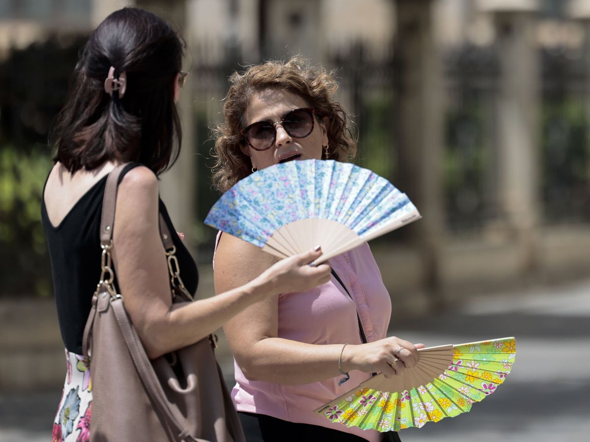 Foto: Dos personas combaten el calor con abanicos (EFE(/Ana Escobar)