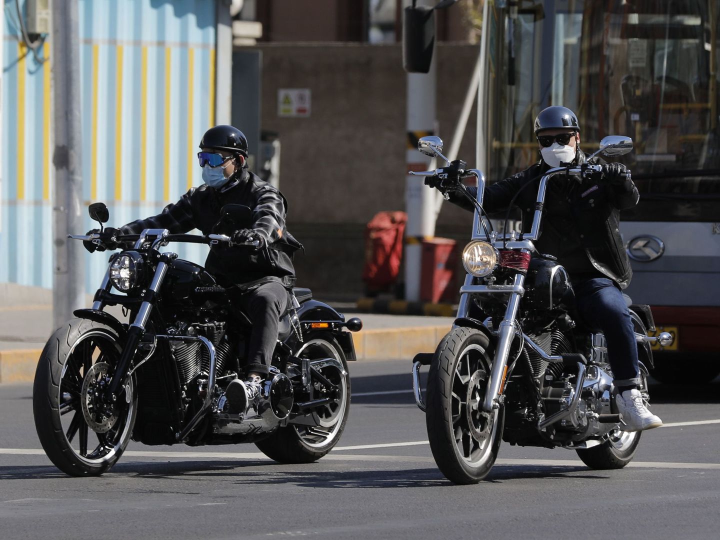 Dos personas con mascarilla conducen sus Harley Davidson en Pekín. (Reuters)