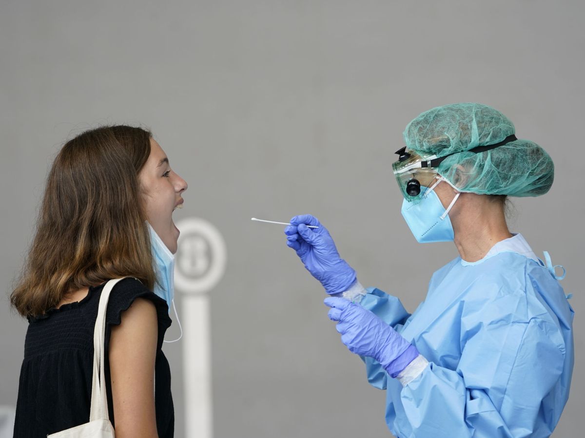 Foto: Una enfermera realiza una prueba diagnóstica del covid-19 a una joven. (Reuters) 