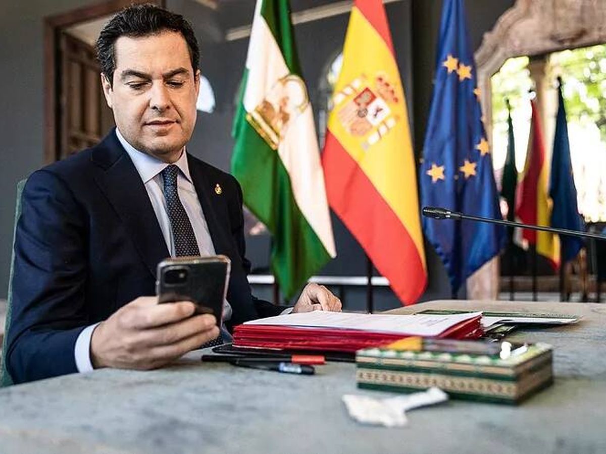 Foto: Juanma Moreno consulta su teléfono móvil en el despacho de San Telmo. (Junta de Andalucía)