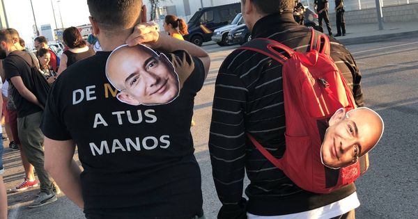 Foto: Dos de los manifestantes con caretas de Jeff Bezos. (M. Mcloughlin)