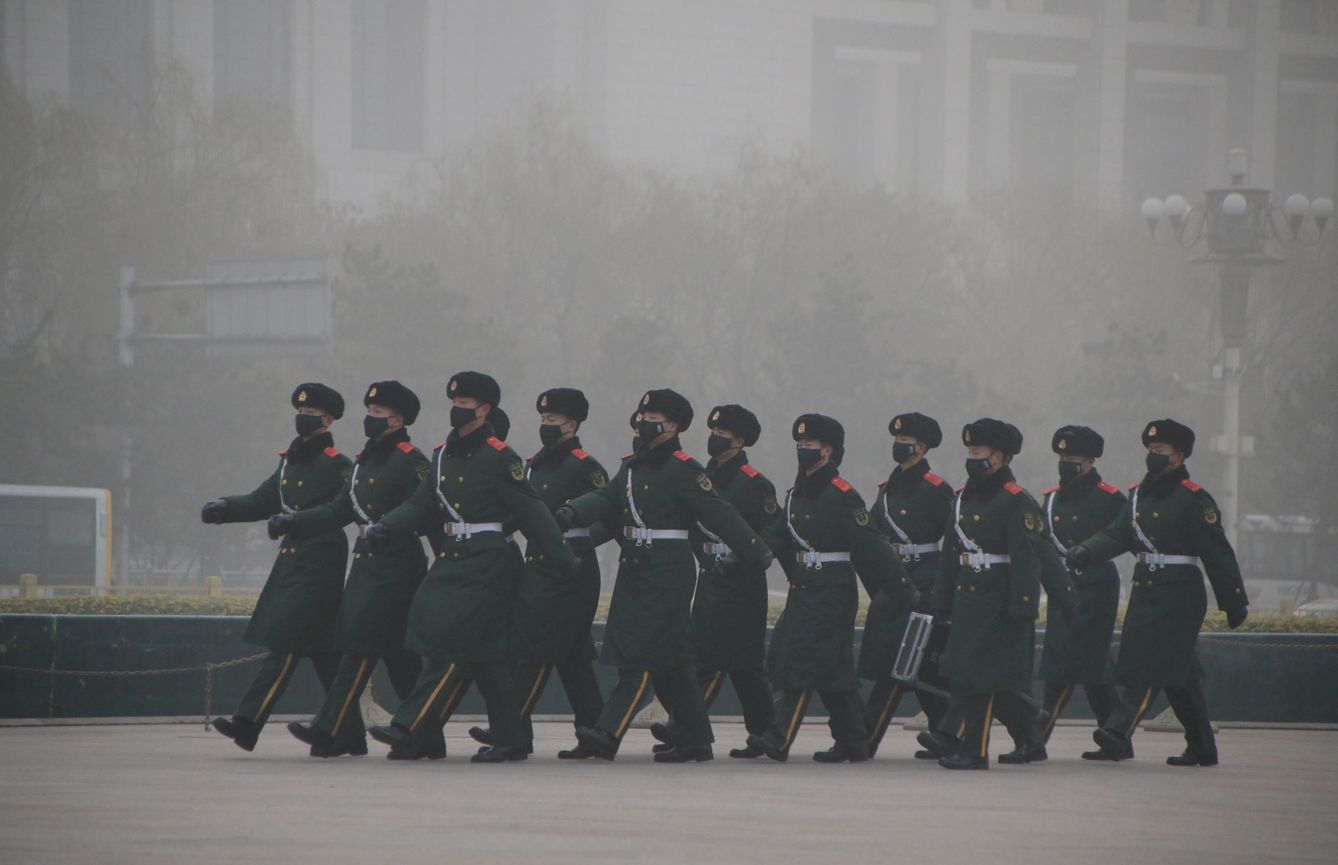 Varios agentes de policía desfilen en medio de la niebla de contaminación de Pekín. (Reuters)