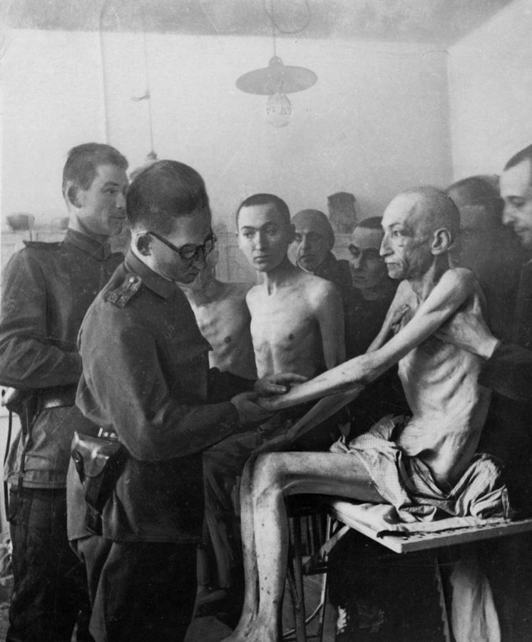 Foto: Un militar sanitario de la ‘Armada Roja’ soviética examina a uno de los supervivientes de Auschwitz tras su liberación el 27 de enero de 1945