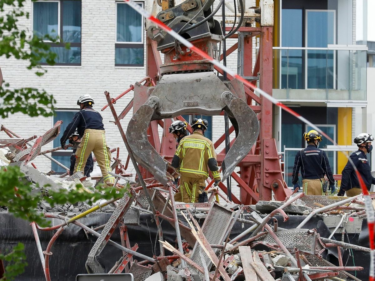 Foto: Unos bomberos trabajan entre los escombros de un edificio derruido. (EFE) 