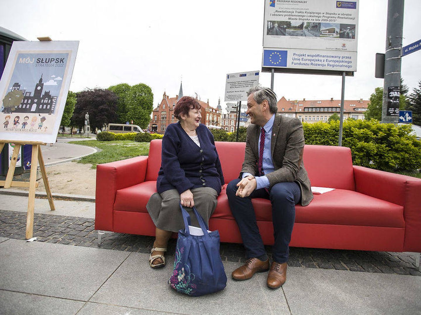 Biedron conversa con sus vecinos en un sofá rojo (Foto del Ayuntamiento de Slupsk)
