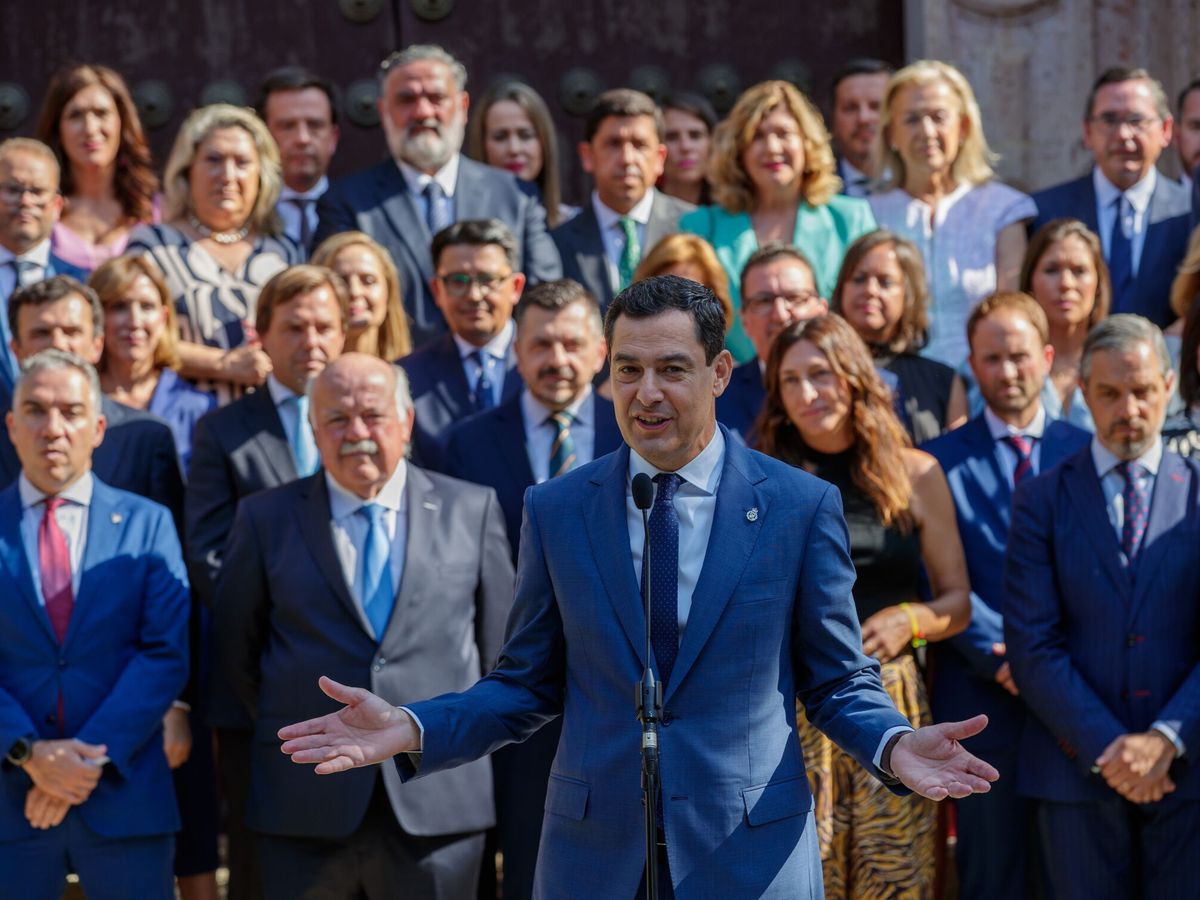 Foto: Juanma Moreno, frente al salón de plenos del Parlamento andaluz, junto a sus diputados. (EFE / Julio Muñoz)