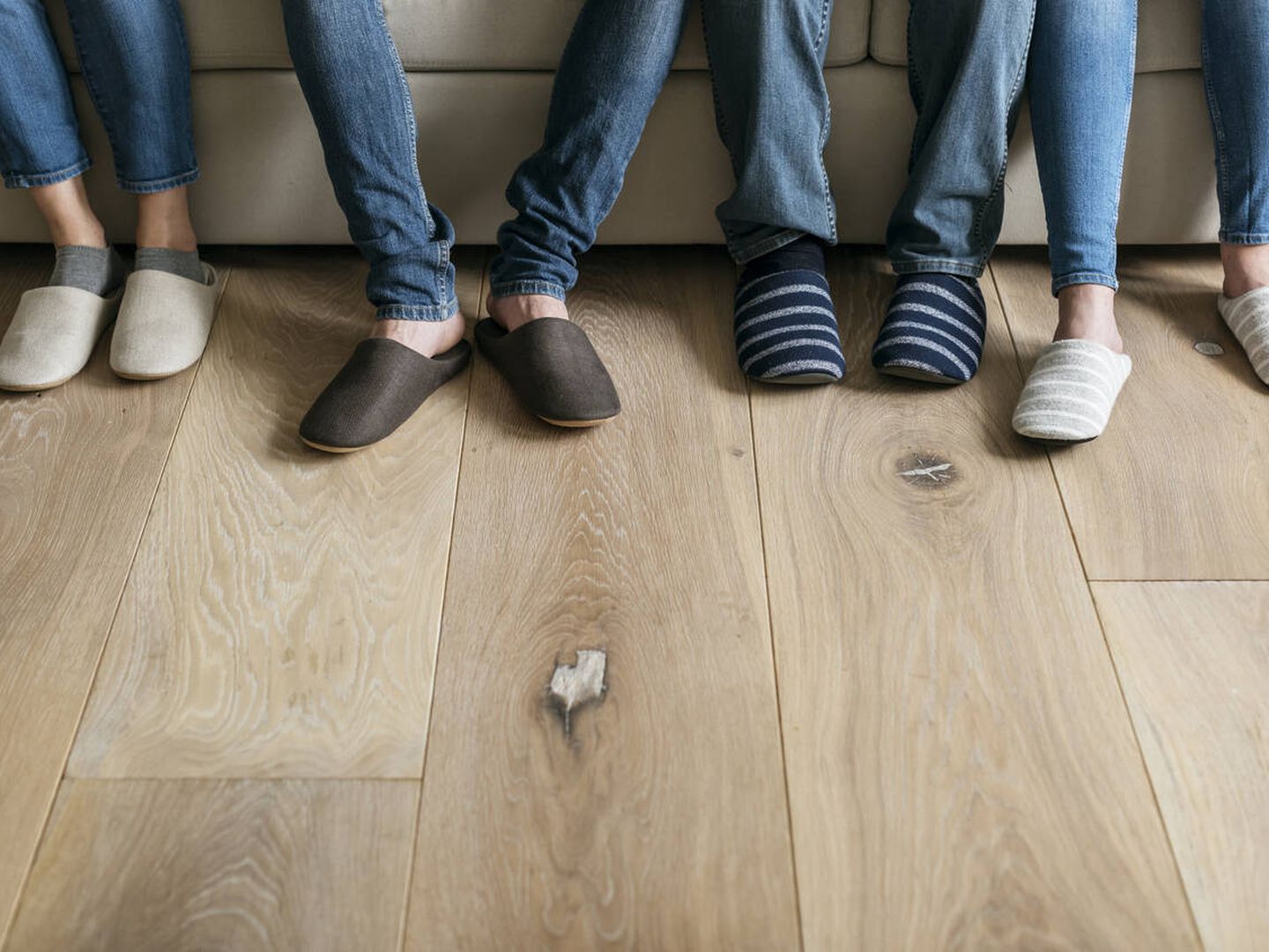 Varias personas con zapatillas de estar por casa (iStock)