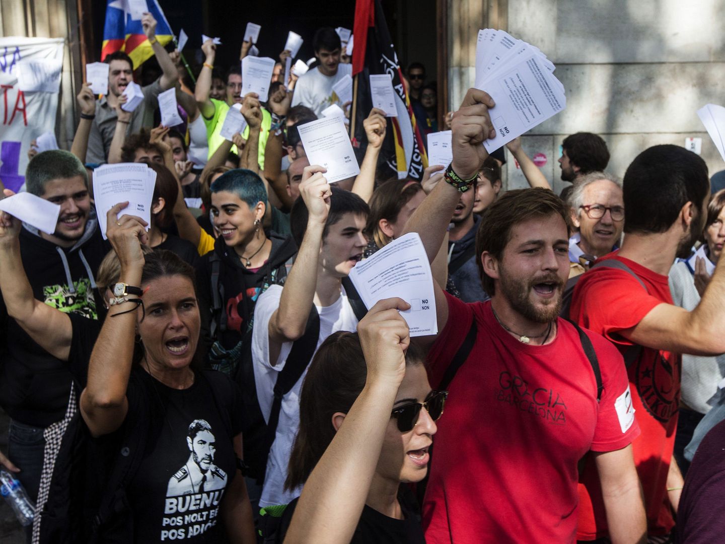 Varios estudiantes salen de la Universidad de Barcelona con papeletas del referéndum. (EFE)