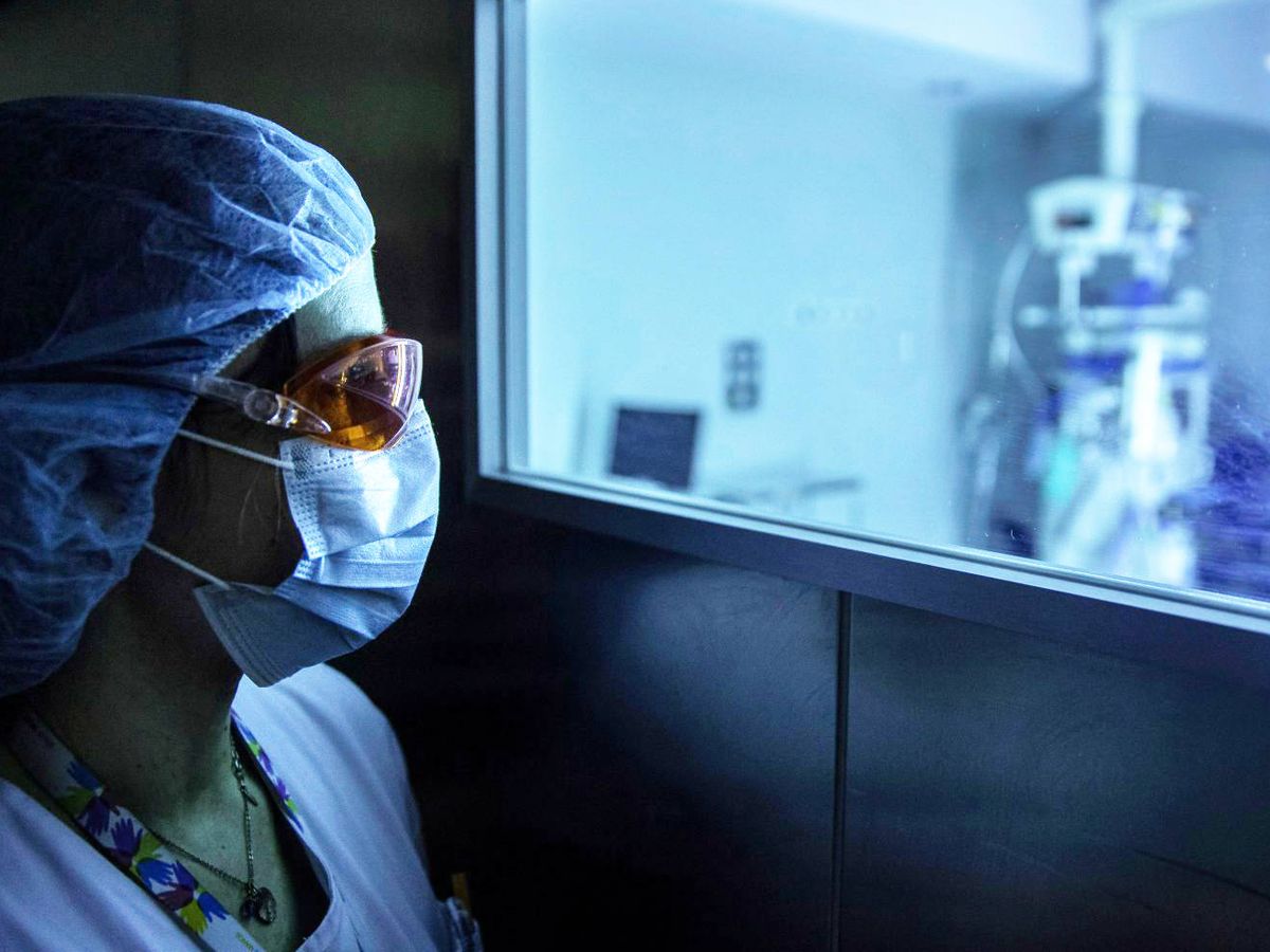 Foto: Una sanitaria observa el funcionamiento de un dispositivo de luz ultravioleta continua (UV-C) móvil que sirve para desinfectar las estancias hospitalarias y eliminar el coronavirus. (EFE)