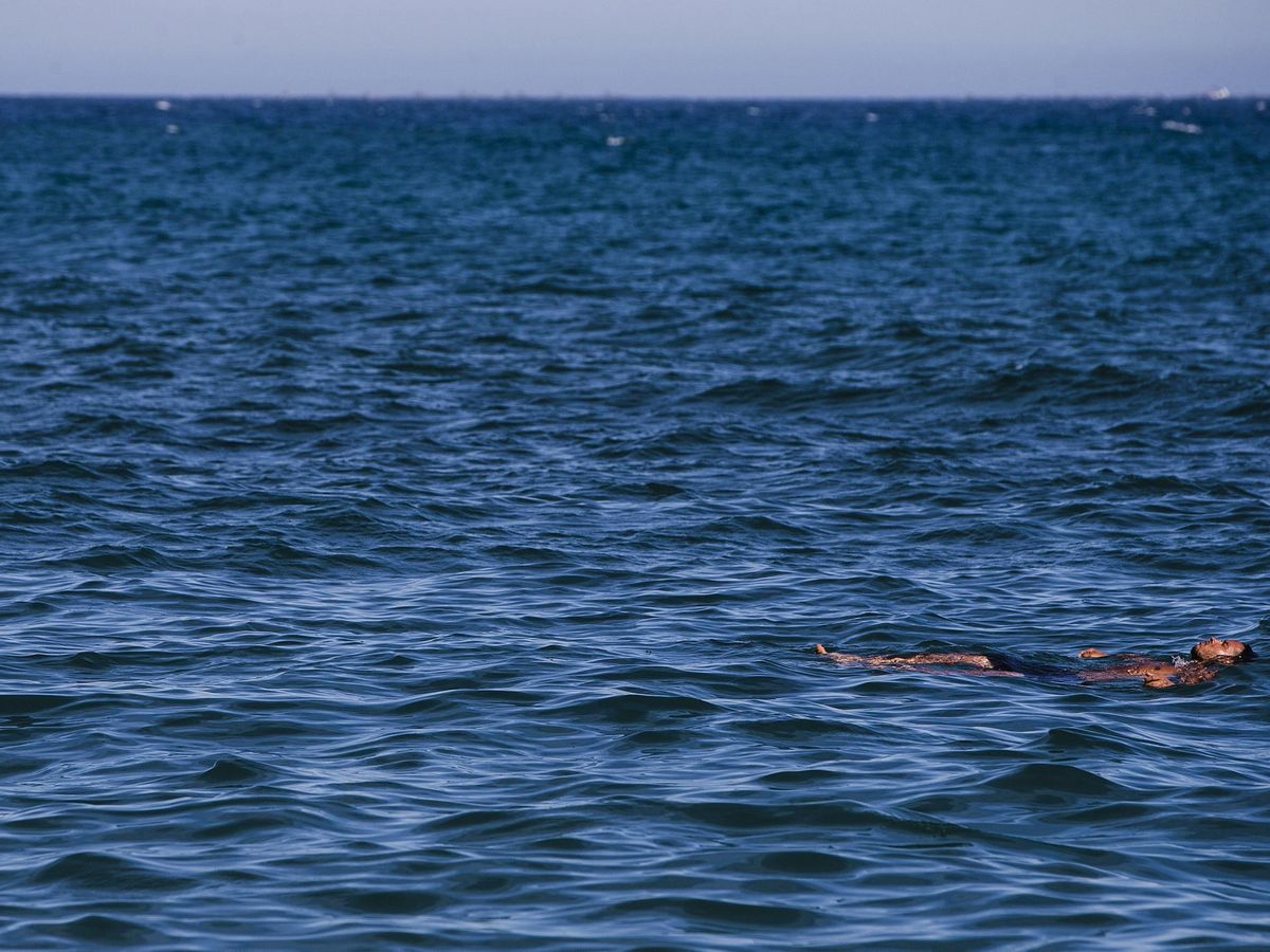 Foto: Una persona flotando en el mar. (EFE/Jorge Zapata)