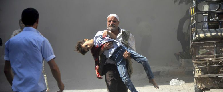 Un hombre traslada a un menor herido en un bombardeo de las fuerzas de Al Asad en Duma, cerca de Damasco (Reuters).